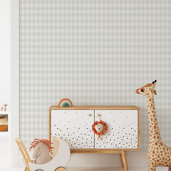 A styled nursery or playroom corner featuring a white and light green diamond-patterned wallpaper on the wall, a mid-century modern wooden cabinet with white doors, a giraffe toy, and a plush elephant in a stroller.