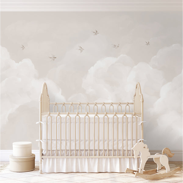 Neutral beige wallpaper featuring airy white clouds and small flying birds in a soft watercolor style, ideal for a minimalist nursery or bedroom.