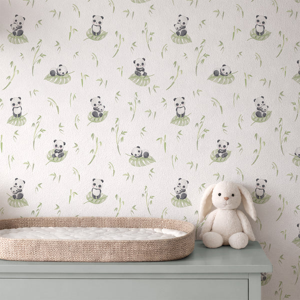 Cute panda nursery wall mural with soft watercolor details, green botanical foliage and a clean white background for a baby or toddler room.