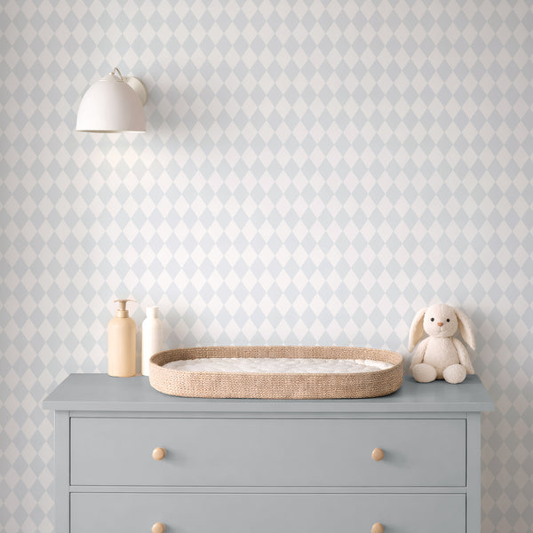 Narrow diamond patterns in pastel blue and off-white create a rhythmic repeat on this wallpaper. With a soft, matte appearance and faint printed grain, it's perfect for adding structure to nurseries or hallways without overpowering existing decor. High-quality removable material allows easy application.
