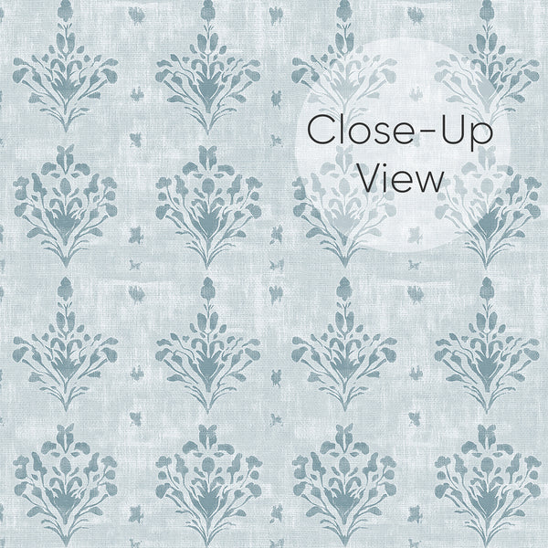 Close up of soft dusty blue wallpaper with a small-scale damask floral pattern and aged textured finish, ideal for a bedroom, powder room or French country interior.