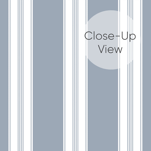 Close up of removable wallpaper in dusty blue and white with alternating broad stripes and narrow pinstripe details for a stylish bedroom accent wall.