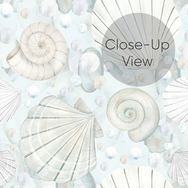 Close up of blue coastal wallpaper featuring hand-painted seashells, ocean pearls, and soft watercolor details for a beach house bathroom or bedroom.