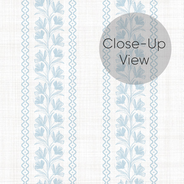 Close up of removable wallpaper in light blue with repeating floral stripe bands, delicate botanical detail, and a soft vintage look for a bedroom accent wall.
