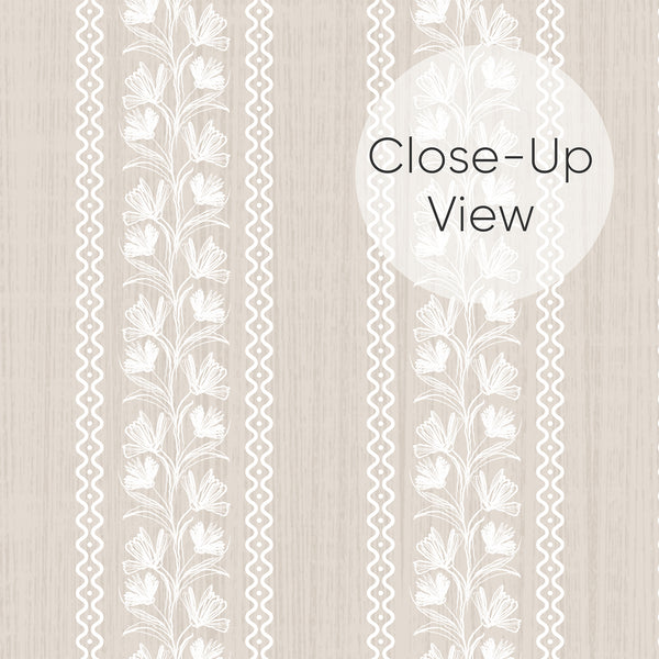 Close up of neutral beige wallpaper with white hand-drawn floral vines and wavy dotted vertical stripes, designed for a cottagecore nursery or cozy bedroom wall.
