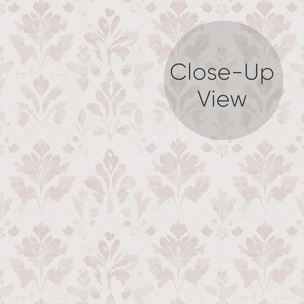 Close up of vintage dusty pink damask wallpaper featuring a small-scale repeating floral motif with softly faded details for French country and cottagecore interiors.