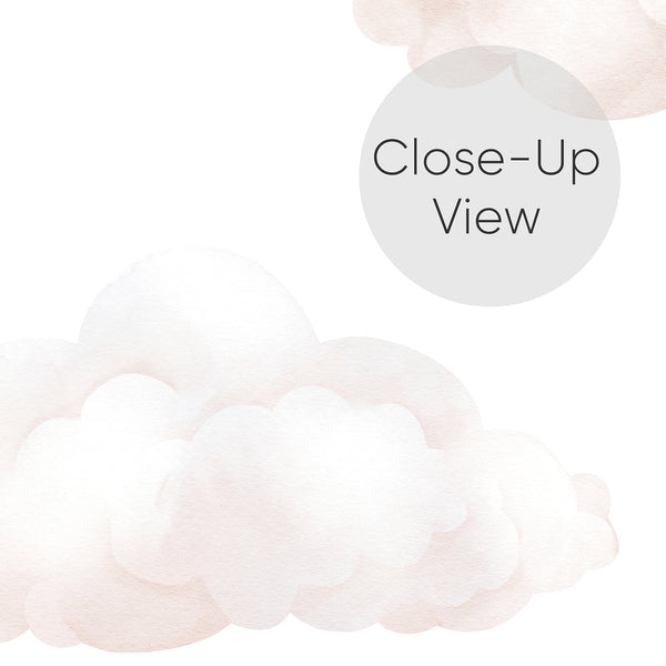 Close up of dreamy nursery wallpaper featuring pale blush clouds in overlapping watercolor shapes for a gentle baby girl room or bedroom accent wall.