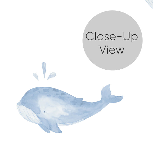 Close up of blue ocean wallpaper featuring a hand-painted whale in soft pastel tones on white for a whimsical nursery, playroom, or toddler bedroom.