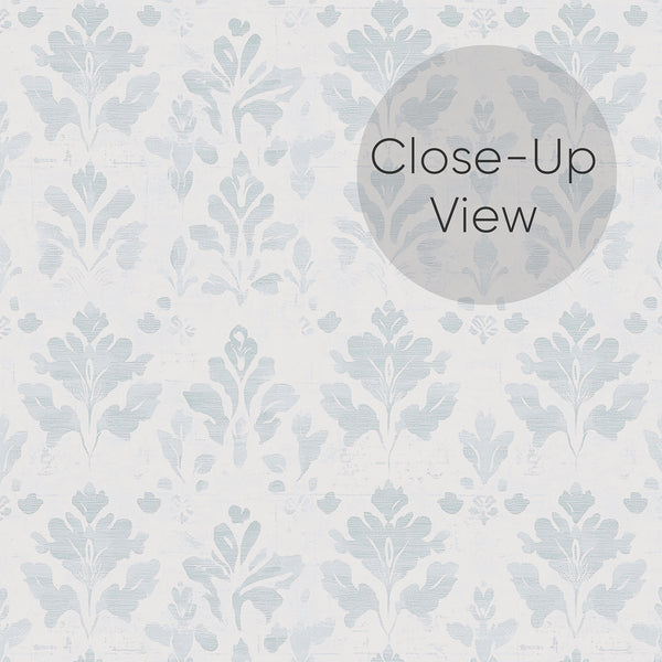 Close up of small-scale damask wallpaper in muted dusty blue and soft white with a vintage weathered texture, ideal for French country and cottagecore interiors.