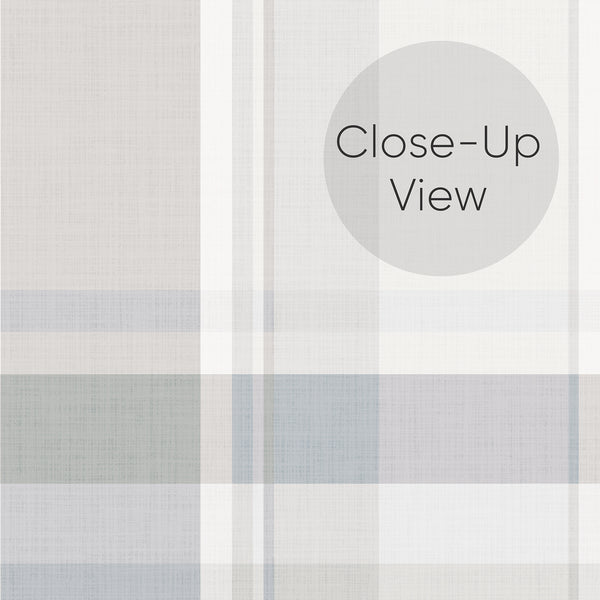 Close up of cottagecore plaid peel and stick wallpaper in dusty blue gray and cream with a classic tartan pattern, perfect for a charming bedroom accent wall.