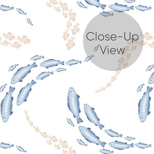 Close up of coastal fish wallpaper featuring hand-painted blue sea life and soft beige fish arranged in playful groups across a bright white background.