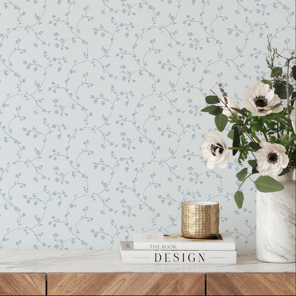 Airy floral vines in dusty blue on a pale blue background, perfect for creating a coastal or cottagecore theme in bedrooms or nurseries. This pre-pasted wallpaper allows easy application and removal, ideal for designers seeking an elegant minimalist wall decor.