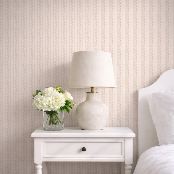 Blush pink floral stripe wallpaper with hand-drawn botanical stems, wavy dotted borders, and a soft cream textured background for a nursery.