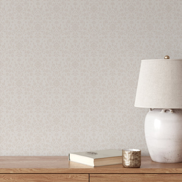 Light beige floral damask wallpaper featuring soft cream flowers, delicate botanical vines and leaves on an ivory background with a subtle woven texture.