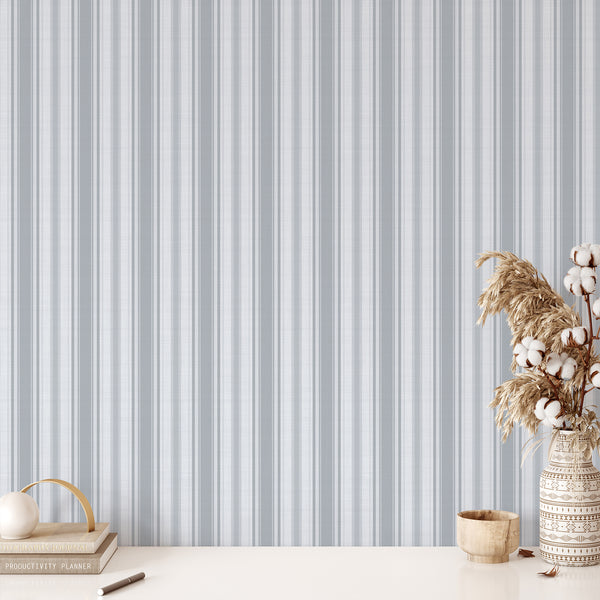 Farmhouse wallpaper featuring muted blue gray vertical stripes with a woven fabric-inspired appearance, bringing understated vintage charm to bedroom accent walls.
