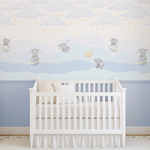 Blue elephant nursery mural with baby elephants among clouds creates a dreamy atmosphere for nurseries. This removable peel and stick design is perfect for modern nursery decor, offering a high-quality, temporary decor solution with watercolor textures and pastel hues.