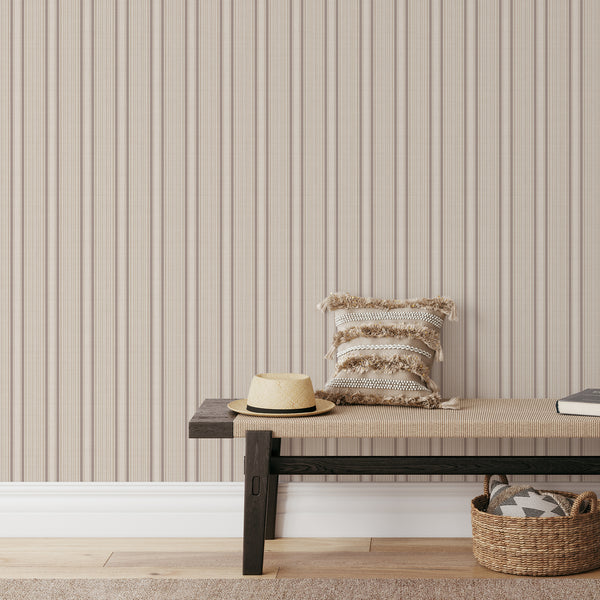 Vintage striped wallpaper with narrow brown and beige vertical lines on a warm cream background, perfect for French country and cozy cottage interiors.