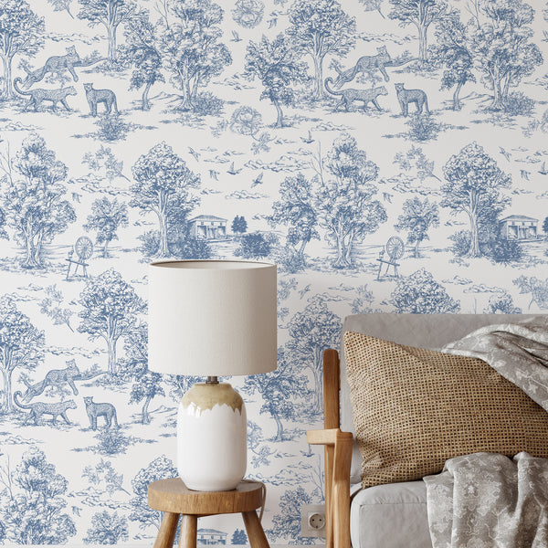 Blue French Toile Safari wallpaper featuring detailed scenic vignettes with trees, birds, and leopards, offering classic French country character for dining rooms or living rooms. Made in the USA, this removable wallpaper is ideal for statement walls in traditional interiors.