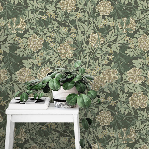 Green and beige Jasmine wallpaper by Morris showcases a dense floral pattern with beige clusters and dark green leaves on a rich background. Ideal for bedrooms or dining rooms, this wallpaper offers a classic, heritage feel.