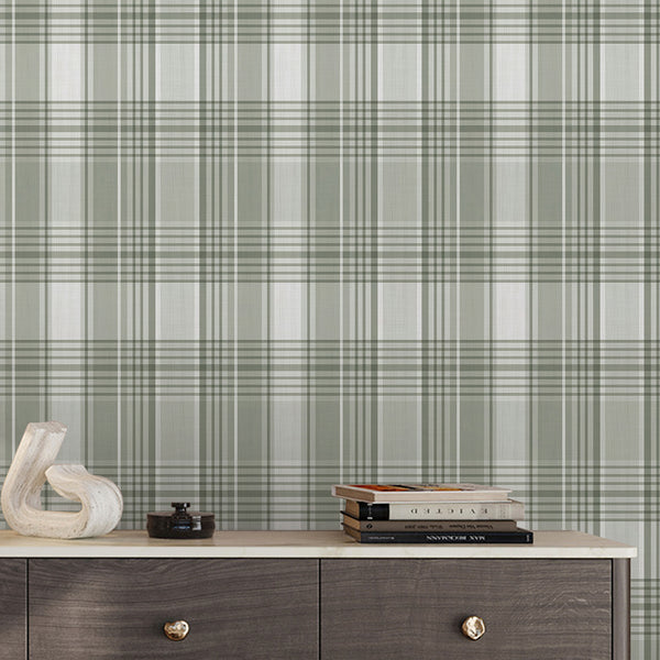 Soft sage green plaid wallpaper with cream intersecting lines and a classic geometric check pattern for a cozy cottagecore bedroom or living room.