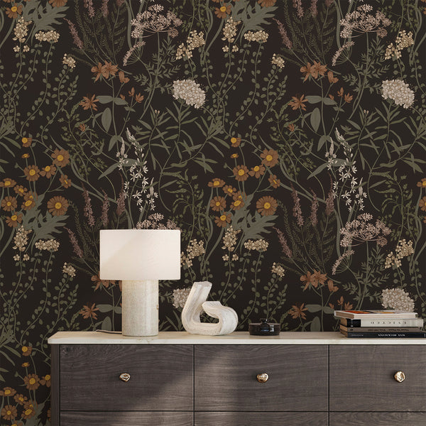 Moody Dark Floral Wallpaper featuring delicate wildflower stems and leaves on a near-black ground. With olive, rust, and muted mustard accents, this vintage-inspired design creates a dramatic statement for dining rooms or eclectic study spaces. Ideal for accent walls, offering removable options.