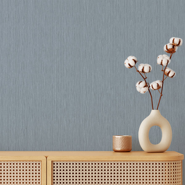 Dusty blue vertical texture wallpaper with fine striated lines, creating a calming backdrop for minimalist and modern interiors.