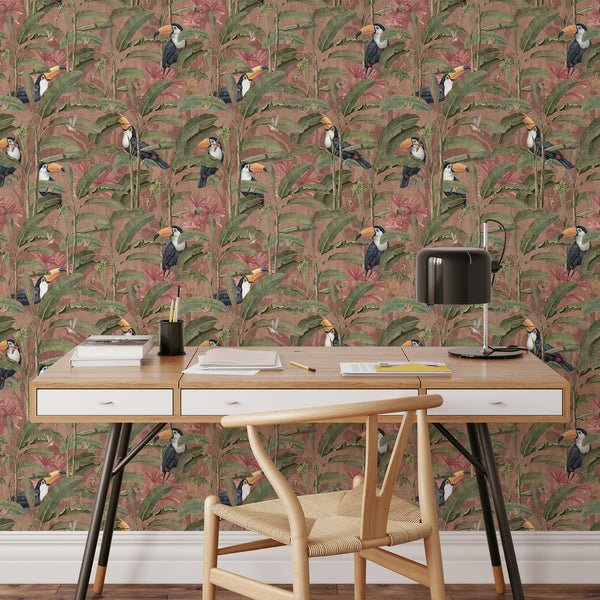 Exotic bird wallpaper with large green banana leaves, tropical toucans and warm pink foliage, ideal for a colorful maximalist bedroom or powder room.