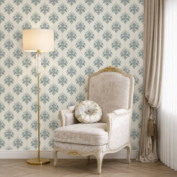 French country damask wallpaper with dusty blue ornamental floral motifs arranged in a repeating pattern on a warm ivory background with subtle texture.