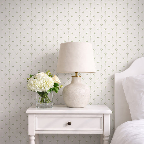 Minimalist botanical wallpaper with muted sage green leaf shapes and dotted stems arranged in a clean repeating pattern on a neutral background.