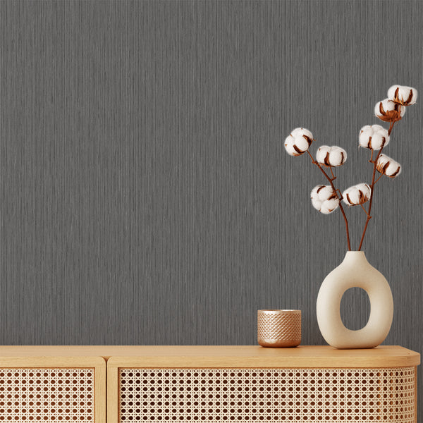 Dark gray wallpaper with vertical striations resembling fabric, offering modern texture for a minimalist living room. Removable peel and stick design, perfect for renters seeking a stylish accent wall.