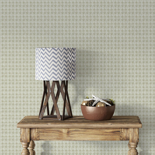 Distressed sage green floral wallpaper with repeating damask ornaments and an aged textured finish for elegant French country and farmhouse interiors.