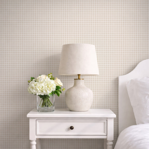 Modern geometric wallpaper featuring a soft beige background with crisp white interlocking trellis shapes for a bedroom, office or living room.