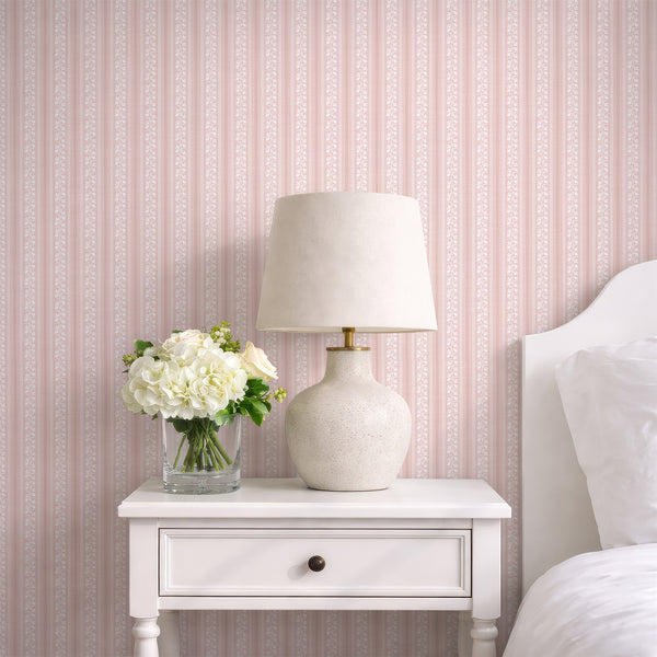 Blush pink floral stripe wallpaper with white hand-drawn flowers, wavy ric rac borders, and a soft textured background for a romantic nursery.