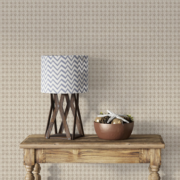 Distressed taupe floral wallpaper featuring repeating damask ornaments over a warm neutral beige texture for elegant French country farmhouse interiors.
