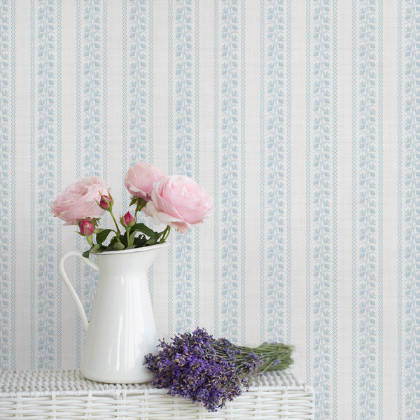 Light blue floral stripe wallpaper with delicate botanical vines, slim wavy borders, and a soft textured background, perfect for nursery or bedroom decor.