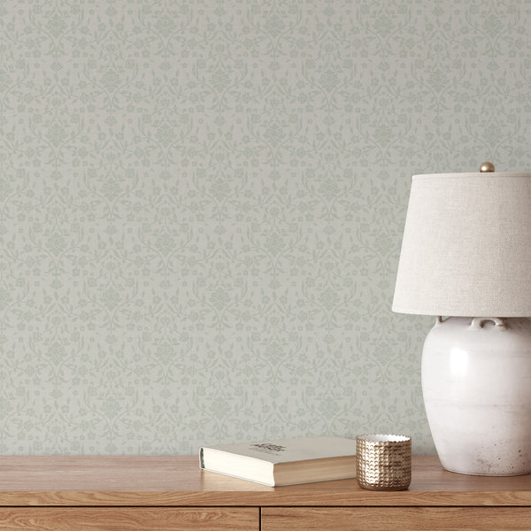 Light sage green floral damask wallpaper featuring delicate green flowers, flowing botanical vines and decorative leaves on a soft ivory textured background.