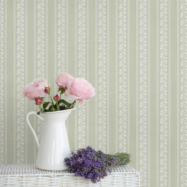 Sage green floral stripe wallpaper with delicate white botanical vines and decorative wavy borders on a soft textured background, ideal for nursery walls and bedrooms.