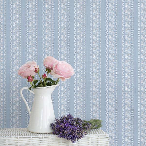 Soft blue floral stripe wallpaper with delicate white botanical vines creates a vintage cottagecore look, perfect for nurseries, bedrooms, bathrooms, and French country interiors.