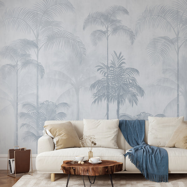 Light blue tropical palm tree wallpaper with tall palms and layered botanical foliage in soft muted tones for a serene modern bedroom.