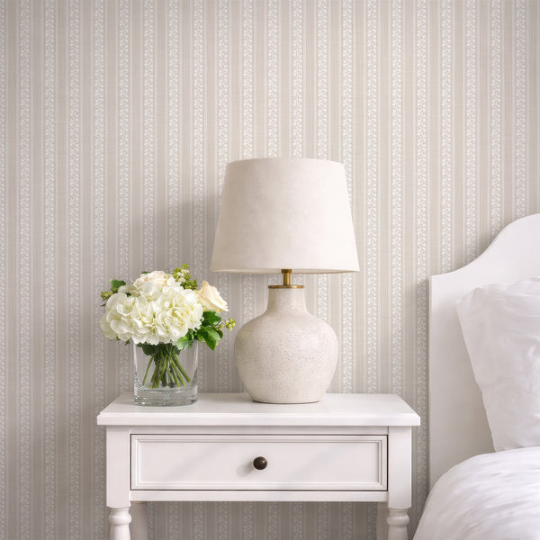 Beige floral stripe wallpaper with white hand-drawn flowers, wavy borders, and subtle texture for cottagecore nursery or farmhouse bedroom decor.