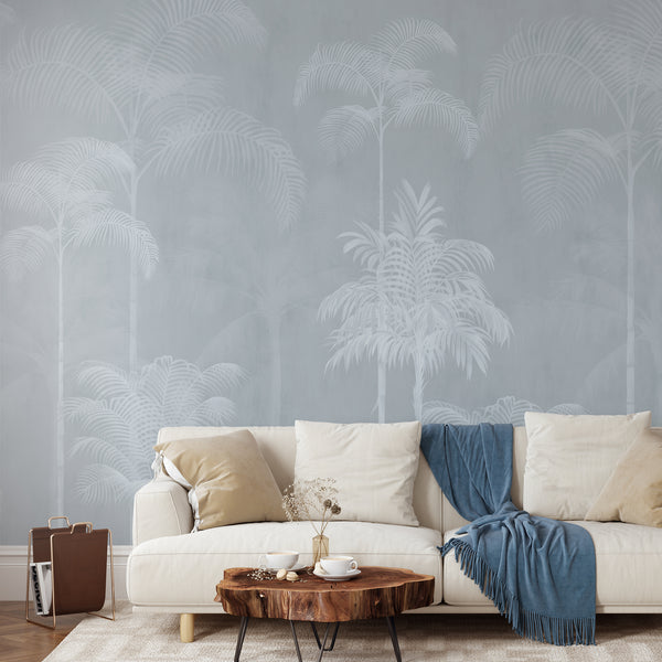 Light blue tropical palm tree wallpaper with soft white palms and layered botanical foliage for an airy modern bedroom or living room interior.