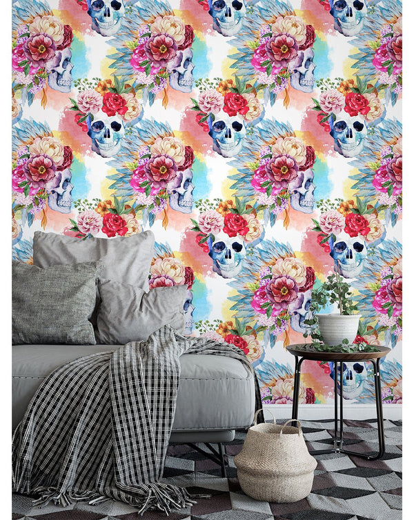 Vibrant floral skull wallpaper with watercolor hues of magenta and peach on bluish-grey skulls, ideal for a powder room wall. The hand-painted texture adds a unique artistic flair.