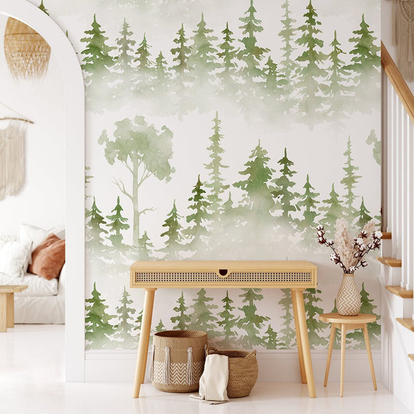 Watercolor forest tree wallpaper featuring soft evergreen silhouettes in misty gray-green hues, perfect for a calming entryway or kid's bedroom accent wall. Made in the USA with eco-friendly materials and easy to apply as removable peel and stick wallpaper, ideal for renters and decorators seeking a nature-themed home decor solution.